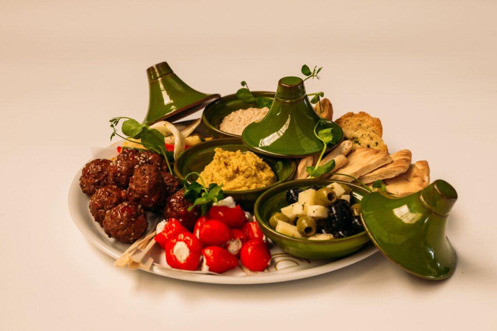 Tafelgarnituur Mezze met pita, hummus, baba ganoush, gegrilde groenten, olijven, feta en halal kipballetjes