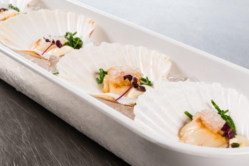 Warme amuse hapje coquille met knolselderij en champagne voor luxe catering evenementen